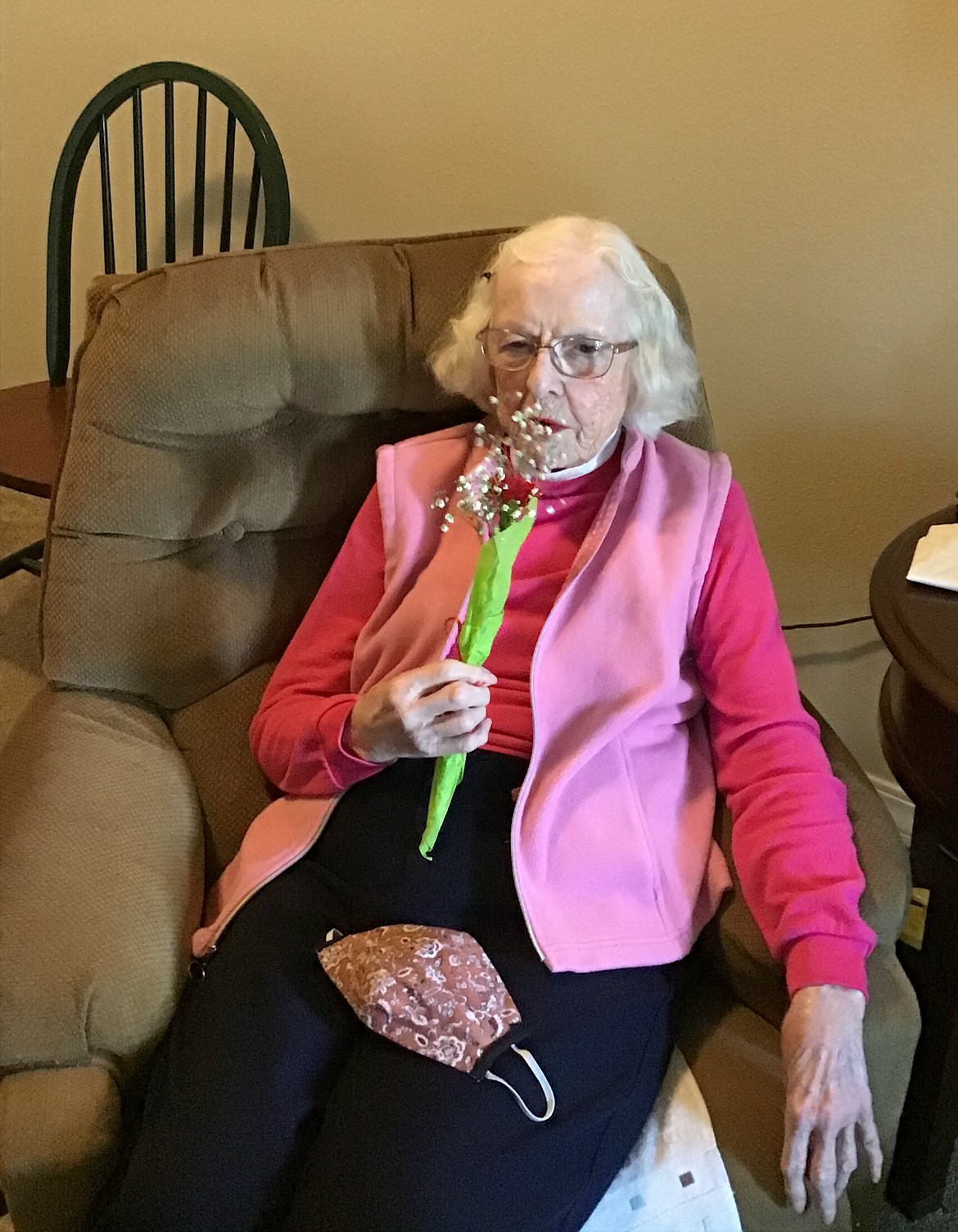 Courtesy photo 
 Betty, a mother and resident of Avamere assisted-living facility in Moses Lake, places her protective mask in her lap while she smells her flowers Sunday.
