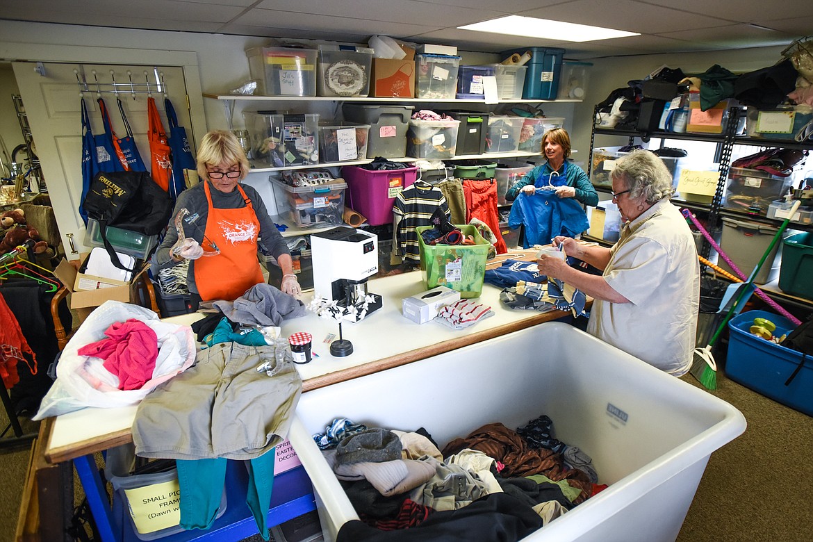 From left, volunteers Rebecca Burns, Lynn Grossman and Kathy Klocow sort through clothing at the Soroptimist Thrift Haus in Whitefish.