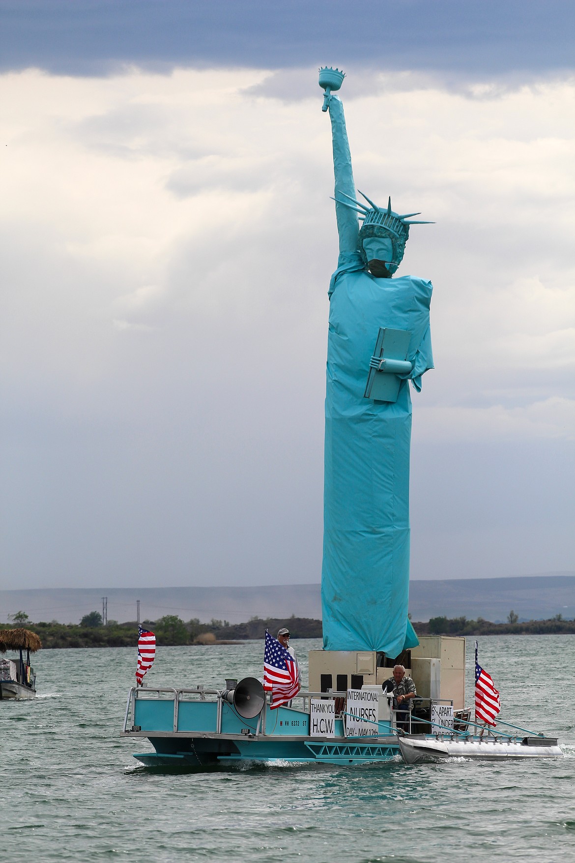 Protective mask and all, Mick Hansen’s Statue of Liberty towered above Moses Lake as patriotic tunes rang out from the boat’s speakers on Tuesday afternoon.