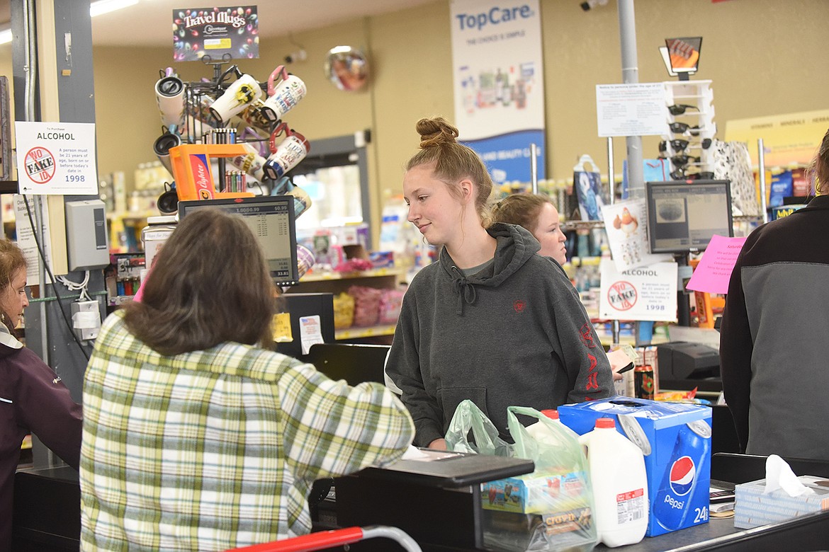 Hot Springs resident Amy McDaniel helps customers through the checkout line last Friday at Buck’s Grocery. (Scott Shindledecker/Valley Press)