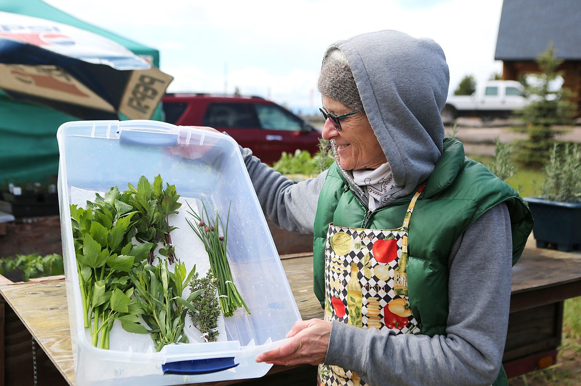 Jackie McCoy of East Shore Produce displays bunches of herbs at her farm stand.