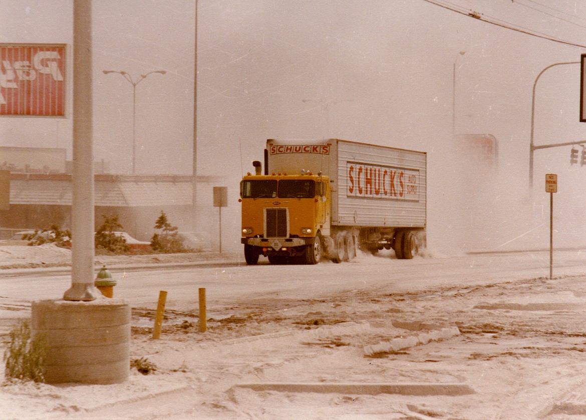 A truck trails a cloud of ash through Moses Lake after the eruption of Mount St. Helens.