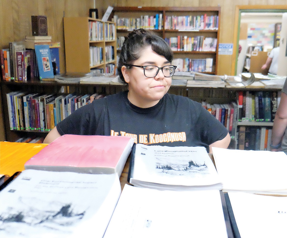 Lincoln County Library Director Alyssa Ramirez looks over a few books as they dry in the basement of Libby’s library Tuesday morning. (Paul Sievers/The Western News)