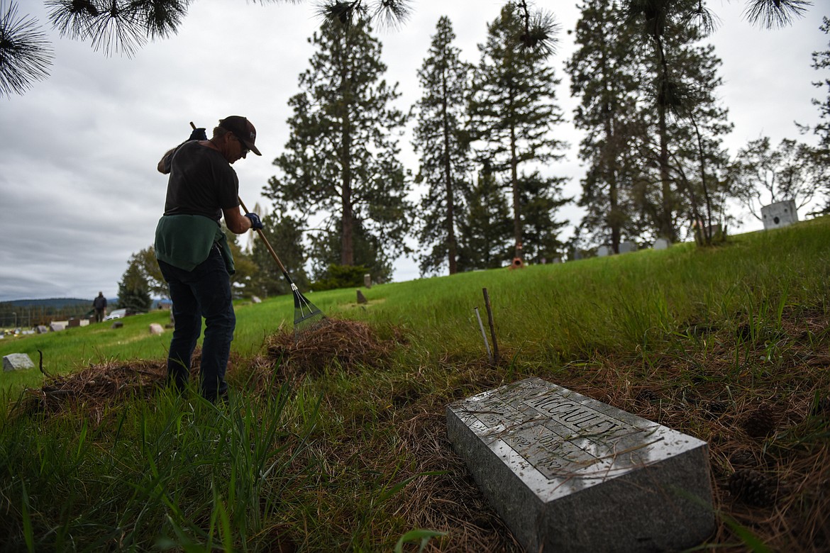 Page Rost rakes debris into piles during the annual cleanup at Lone Pine Cemetery in Bigfork on Friday, May 15. (Casey Kreider/Daily Inter Lake)