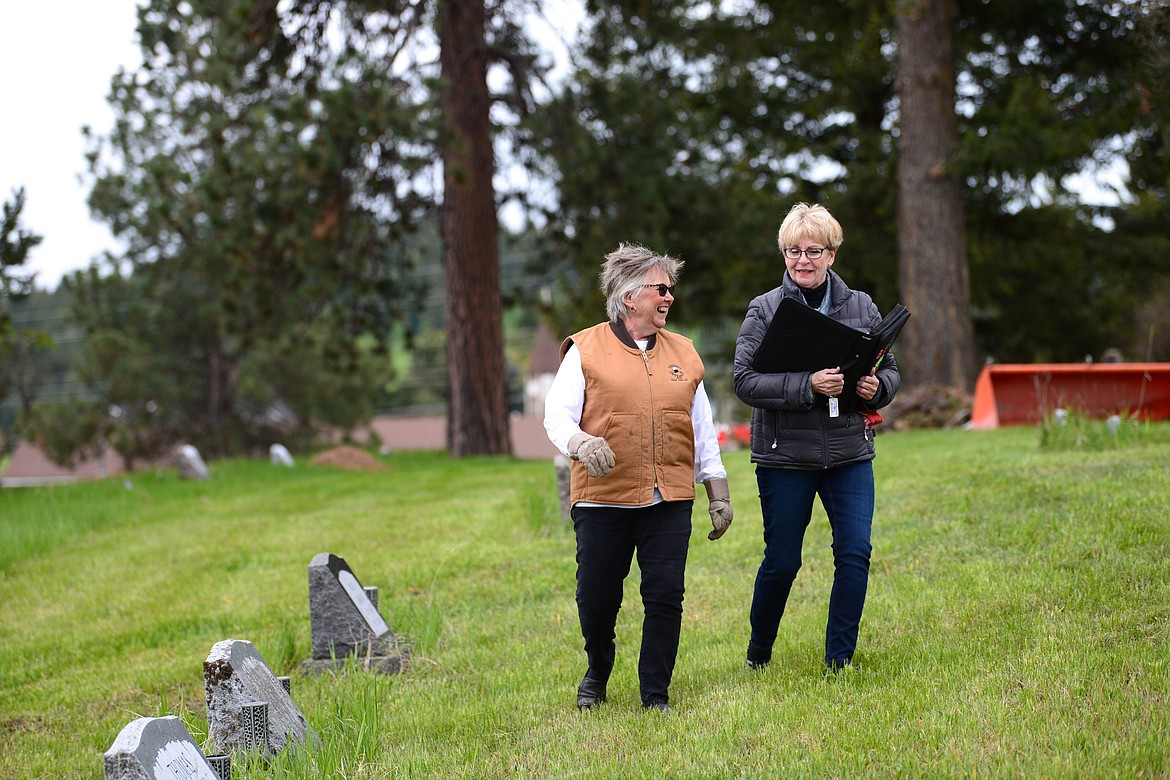 Arlene Wilson, left, and Darlene Smith take a break from cleaning up debris at Lone Pine Cemetery in Bigfork on Friday, May 15. (Casey Kreider/Daily Inter Lake)