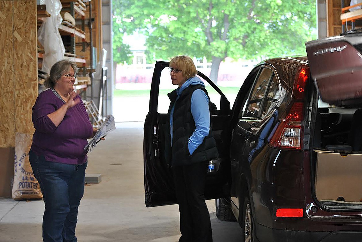 Frugal Boxes Co-op founder Debbie Kelsey briefly chats with Linda Reineke from St. Regis as she picks up her produce baskets for her and a friend on May 23.  (Amy Quinlivan/Mineral Independent)