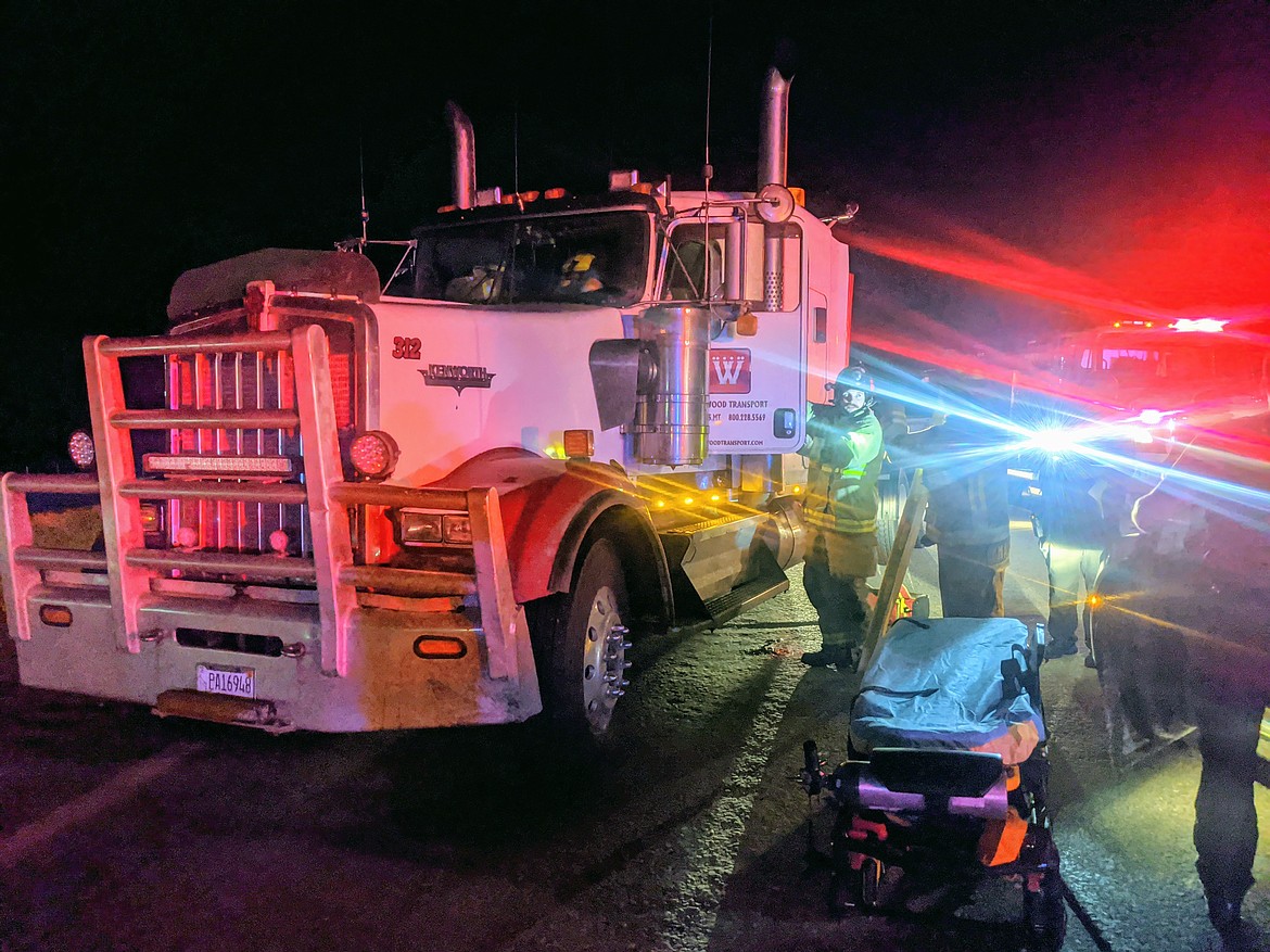 Emergency crews from Shoshone County Fire District No. 1 work to remove the semi-truck driver from the driver's seat. No major injuries were reported.