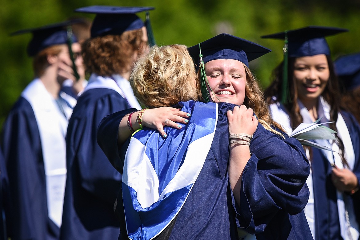 Graduate Liv Wilson, right, gets a hug from Glacier High School spanish teacher Heidi Emerson before the start of the school's commencement ceremony at Legends Stadium on Saturday, May 30. Wilson graduated Magna Cum Laude with international language and several other honors. (Casey Kreider/Daily Inter Lake)
