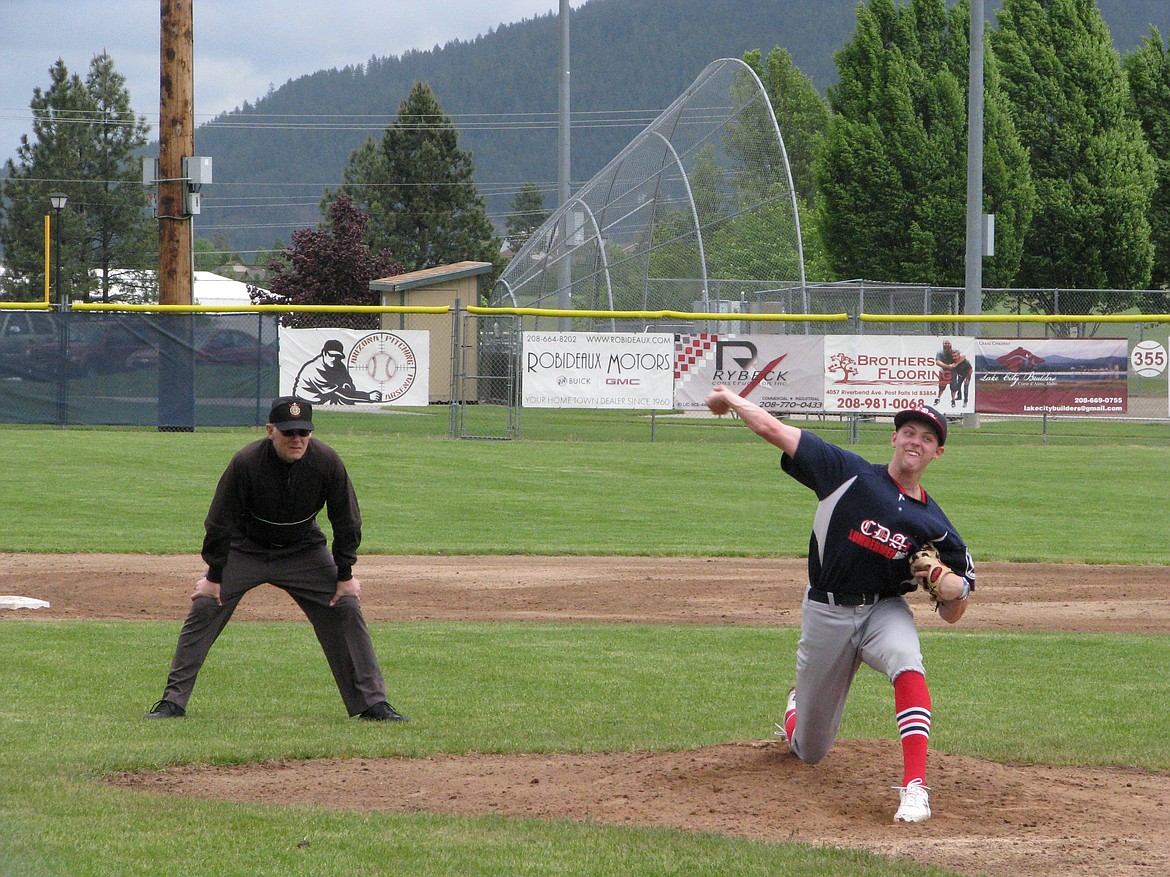 Alex Karns of the Coeur d’Alene Lumbermen fires a pitch against the Spokane Crew 18U on Sunday at Thorco Field. The umpire positioned behind him called balls and strikes.