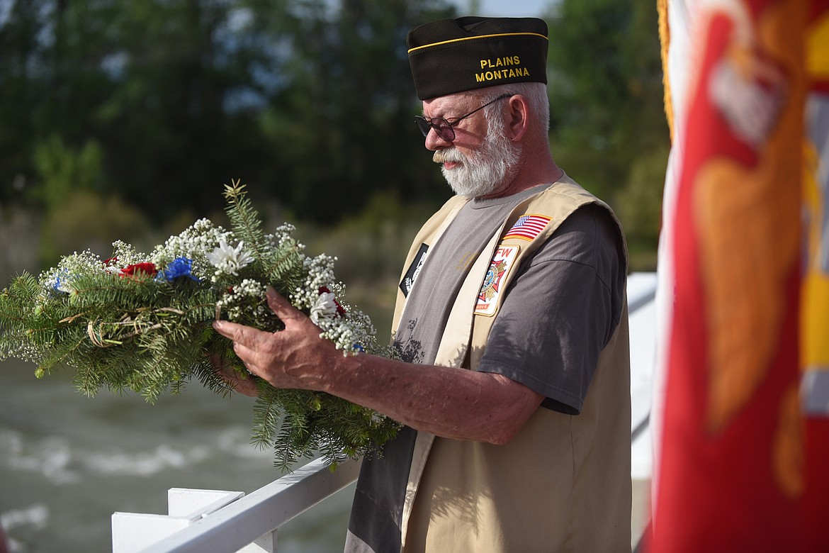 PLAINS VFW member Gary Jenson, a Navy vet, prepares to toss a wreath into the Clark Fork River last Saturday during the group’s annual remembrance of those who died while serving in the United States Armed Forces. (Scott Shindledecker/Valley Press)