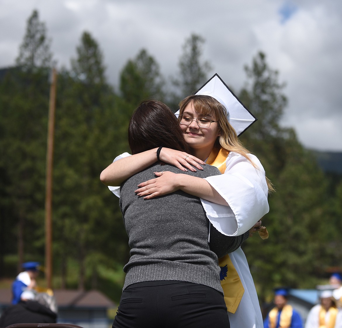 AIDEN MARY Rosales hugs her mom, Christine Leischner, after presenting her a white rose during Sunday’s graduation ceremony at Thompson Falls High School. (Scott Shindledecker/Valley Press)