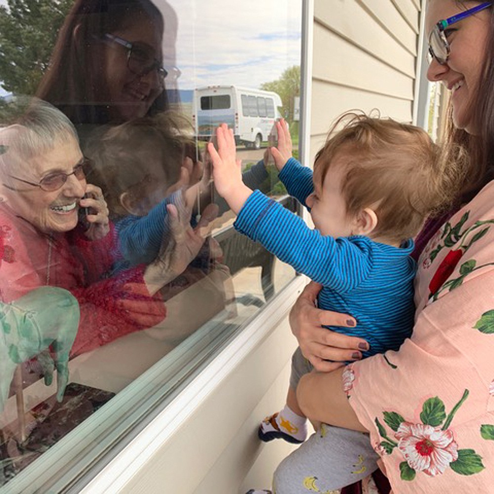 Nine-month-old Matthias, along with his mother Micha, stop by to see Matthias’ great-grandmother Mimi for a special Mother’s Day visit at St. Joseph’s Assisted Living in Polson. With assisted-living centers and nursing homes still closed to visitors, many families have arranged visits through the facilities’ windows. (Photo Courtesy Cheryl R. Maldonado)