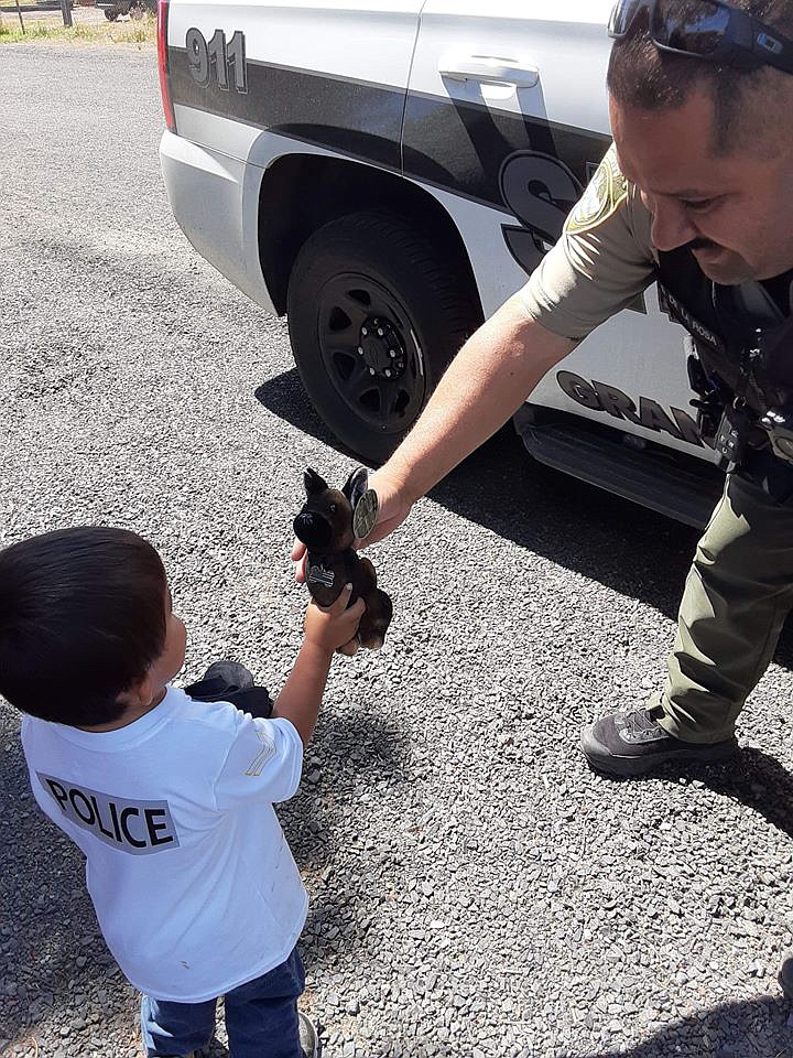 Grant County Sheriff’s Office Deputy David De La Rosa gives young Olekzander Lopez a stuffed canine on his birthday on Sunday after Deputy De La Rosa stopped by to surprise the young man.