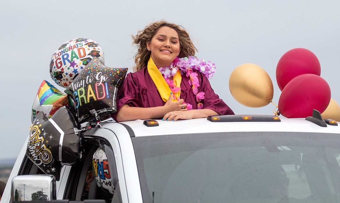 Casey McCarthy/Columbia Basin Herald 
 A Moses Lake High School graduate flashes a smile while leaving Grant County Fairgrounds.