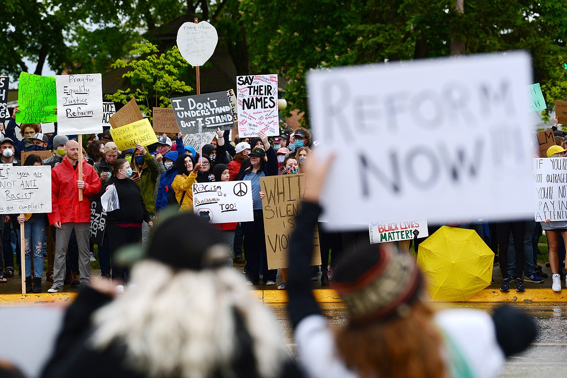 Protesters hold signs along both sides of North Main Street at Depot Park during a protest denouncing police violence against people of color in Kalispell on Saturday, June 6. (Casey Kreider/Daily Inter Lake)