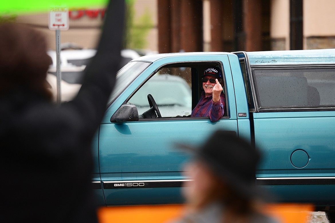 A man holds up his middle finger as he drives past a group of protesters at Depot Park during a protest denouncing police violence against people of color in Kalispell on Saturday, June 6. (Casey Kreider/Daily Inter Lake)