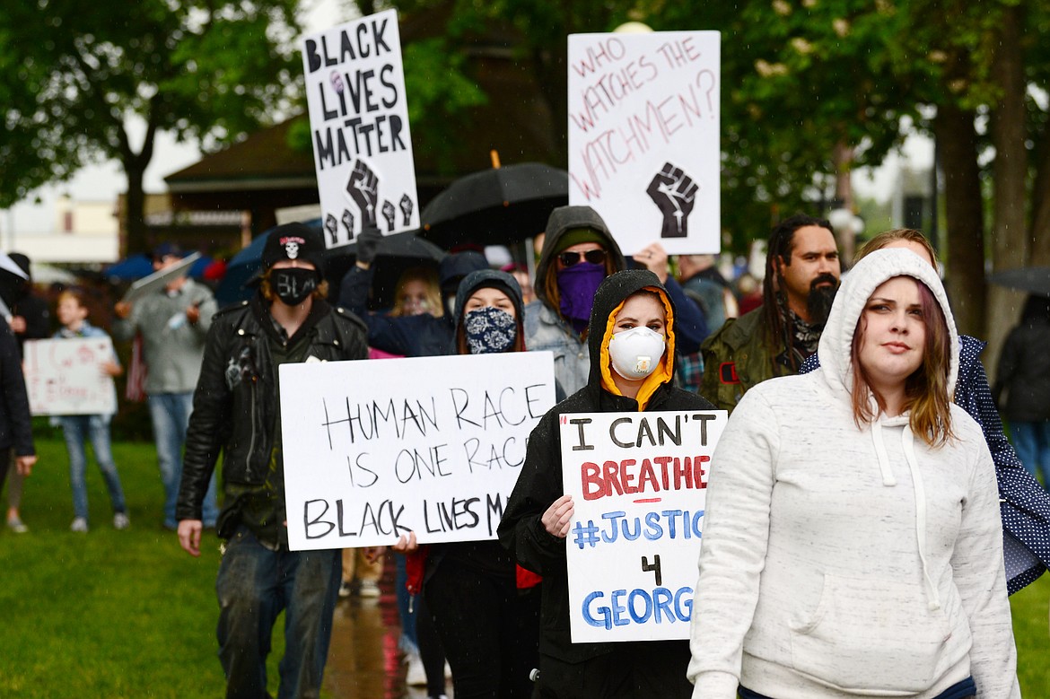 Protesters hold signs at Depot Park during a protest denouncing police violence against people of color in Kalispell on Saturday, June 6. (Casey Kreider/Daily Inter Lake)
