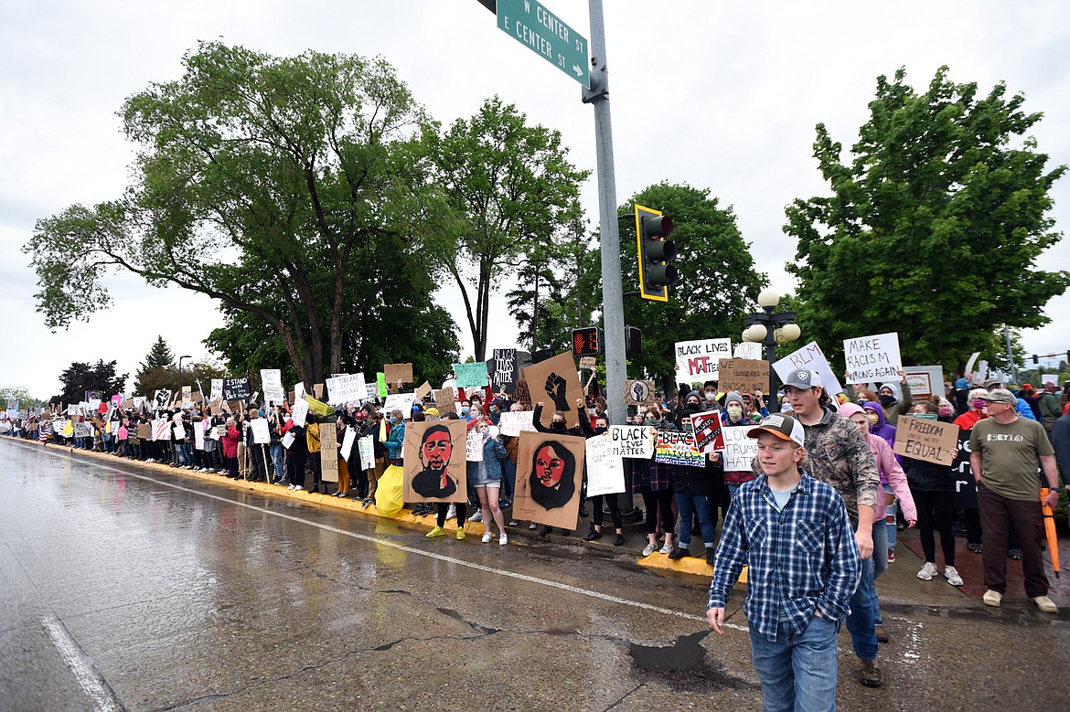 Protesters hold signs along North Main Street at Depot Park during a protest denouncing police violence against people of color in Kalispell on Saturday, June 6. (Casey Kreider/Daily Inter Lake)