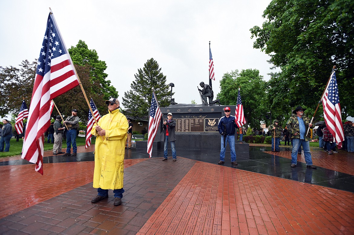 A group of people unassociated with the protest gather to watch over the Veterans Memorial at Depot Park during a protest denouncing police violence against people of color in Kalispell on Saturday, June 6. (Casey Kreider/Daily Inter Lake)