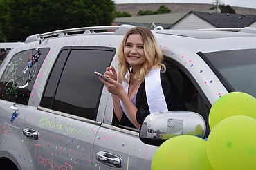 Charles H. Featherstone/Columbia Basin Herald 
 Ephrata High School senior Jessie Kehn leans out the window of her family's SUV in preparation for the EHS drive-through graduation ceremony on Friday.