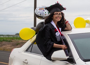 A Royal High School graduate can do nothing but smile as she hangs out the car window, heading out for graduation parade on Friday night in Royal City.