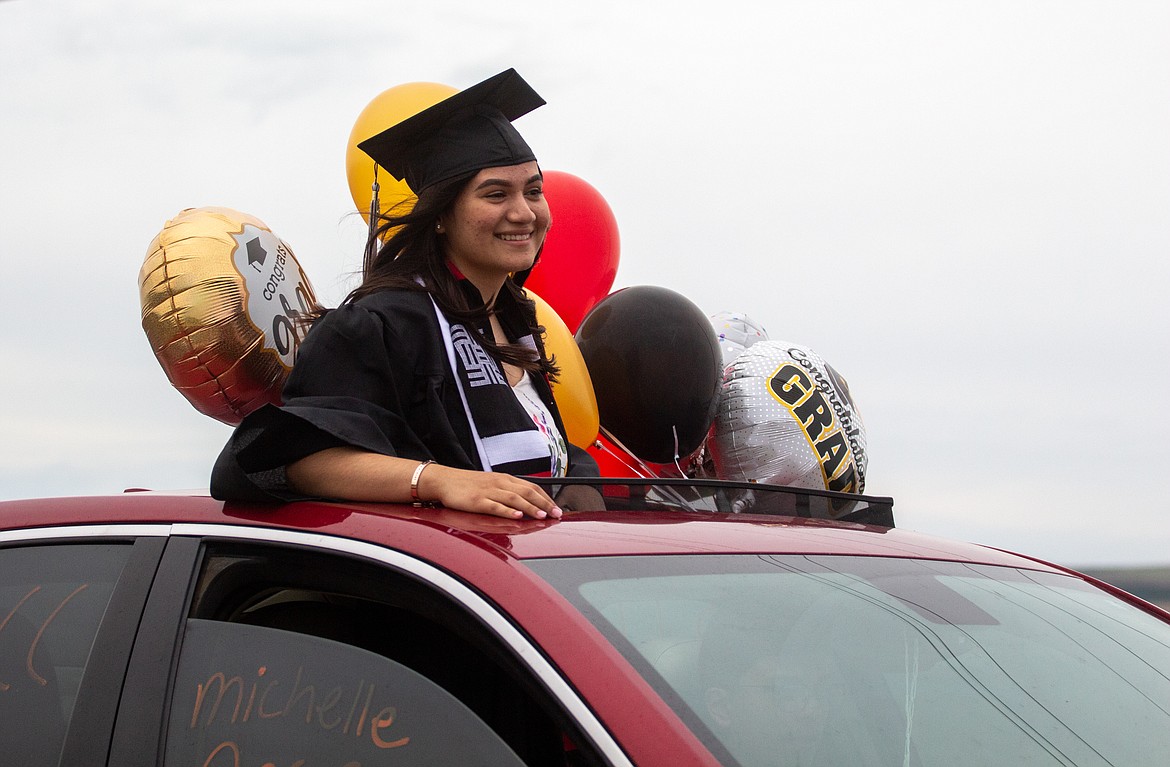 A RHS senior smiles as she and her family head out during the graduation parade on Friday night in Royal City.