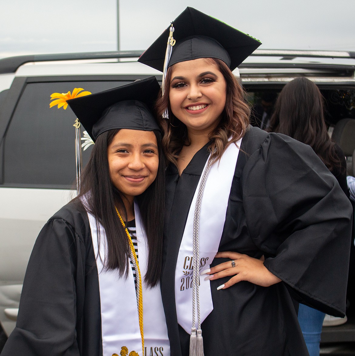 Royal High School graduates smile together in the parking lot before the graduation parade begins on Friday night.