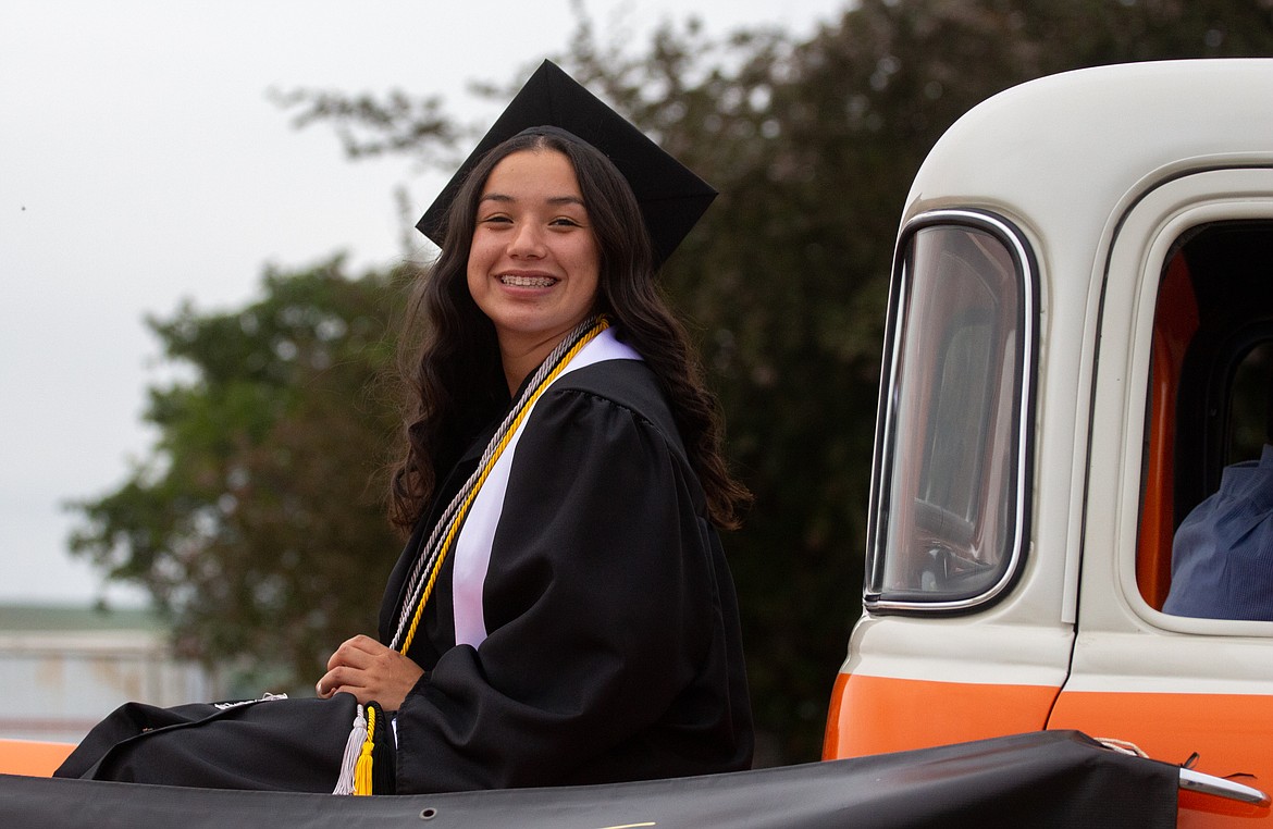 A Royal High School graduate smiles quickly as she passes by during the graduation parade for the 2020 seniors Friday night.