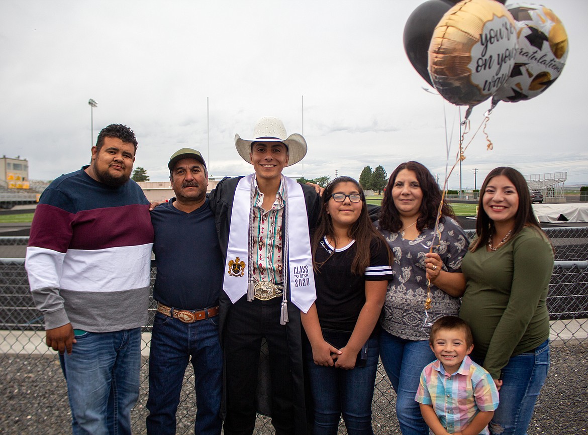 A 2020 Royal High School graduate poses for a photo with his family before ceremonies get started Friday evening in Royal City.