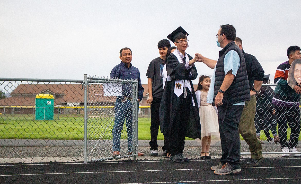 A fist bump is waiting for the graduating Royal High School senior as he makes his way towards crossing the stage on Friday evening