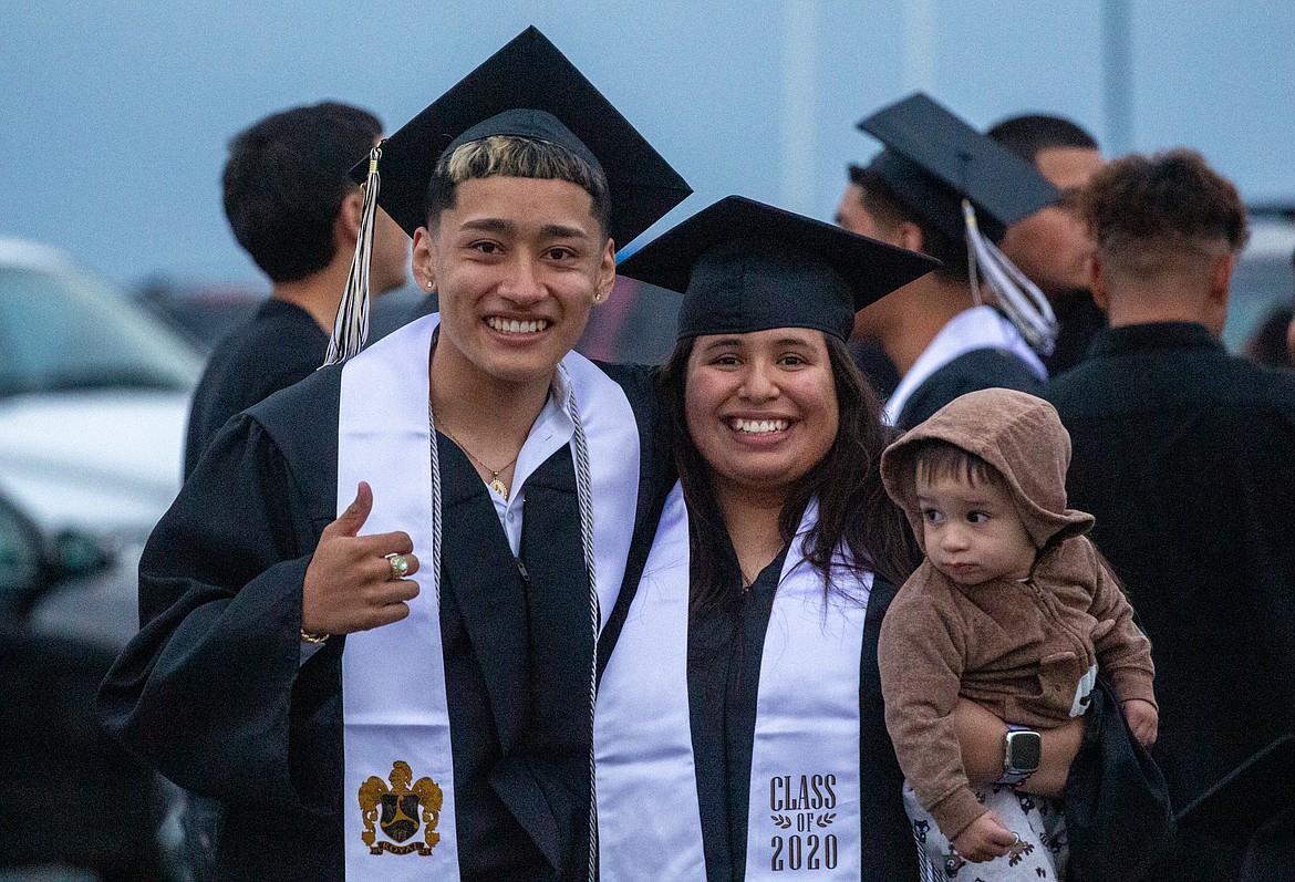 A pair of 2020 RHS graduates pose for a photo together after walking across the stage with their families on Friday evening at David Nielsen Memorial Field.