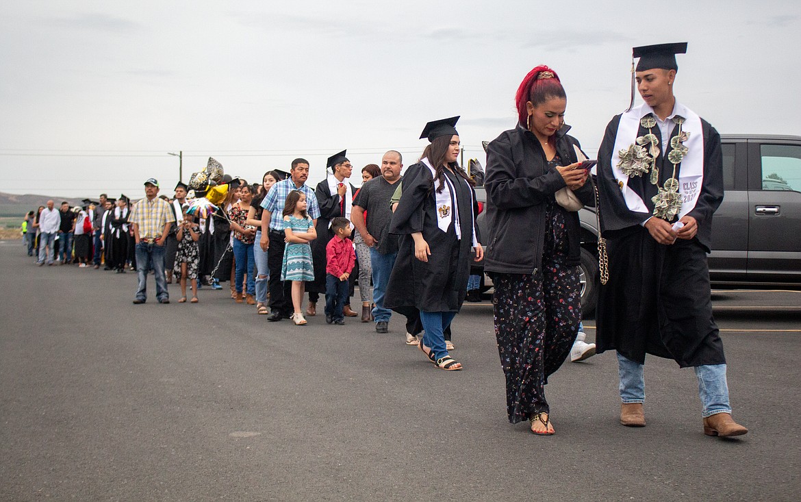 Royal High School seniors and their families wait in line in the parking lot beside David Nielsen Memorial Field with graduation looking a lot different in 2020 given the social distancing protocols in place.
