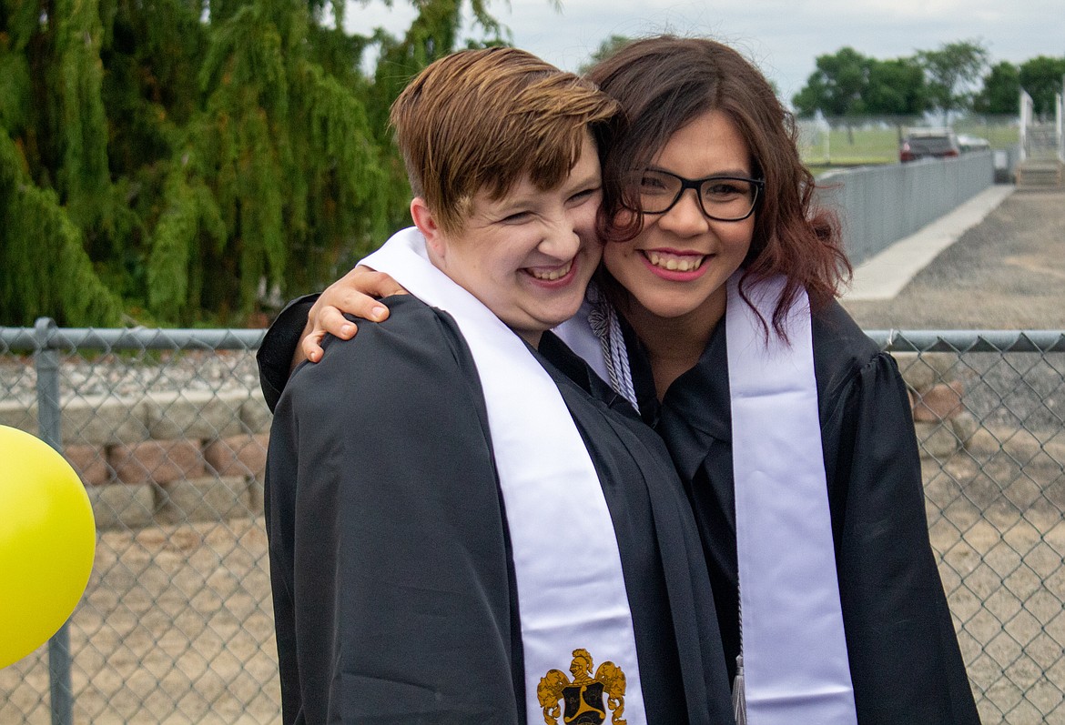 Two Royal graduates share a fun moment before ceremonies get started on Friday night beside David Nielsen Memorial Field.