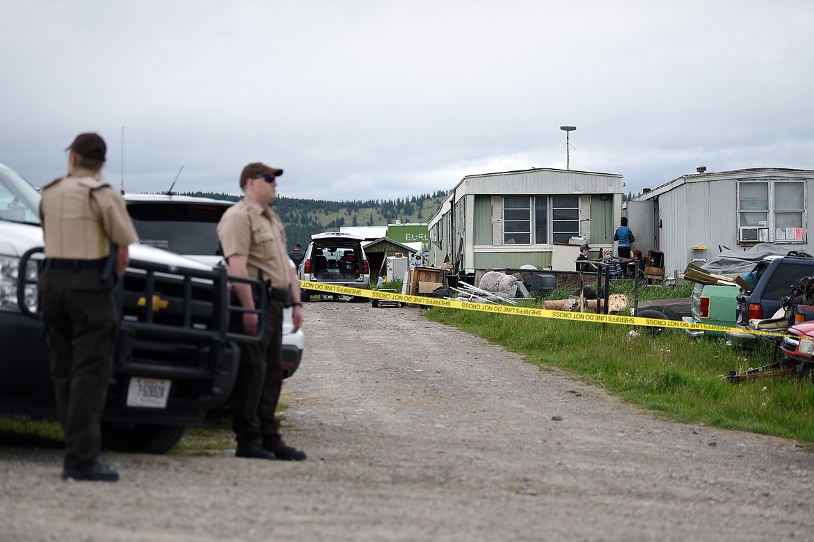 Deputies with the Flathead County Sheriff’s Office stand at the scene of an alleged homicide along Cobbler Village Terrace west of Kalispell on Tuesday, June 9. (Casey Kreider/Daily Inter Lake)