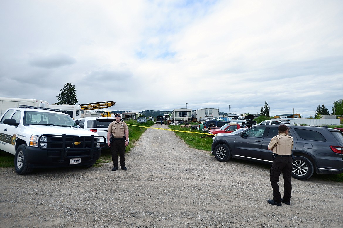 Deputies with the Flathead County Sheriff’s Office stand at the scene of an alleged homicide along Cobbler Village Terrace west of Kalispell on Tuesday, June 9. (Casey Kreider/Daily Inter Lake)