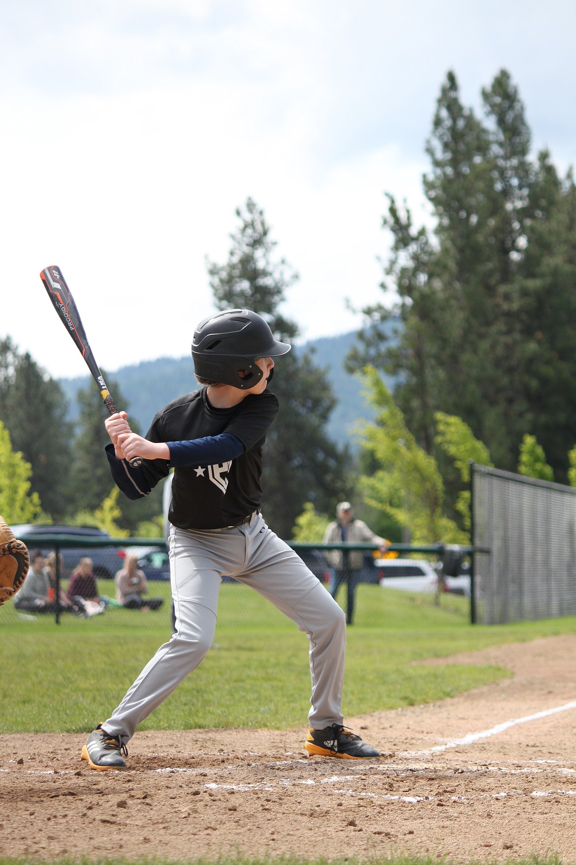 Colton Gookin of the Post Falls Black takes a swing in a game against the Post Falls Orange Sox in a Post Falls Little League 14U game.