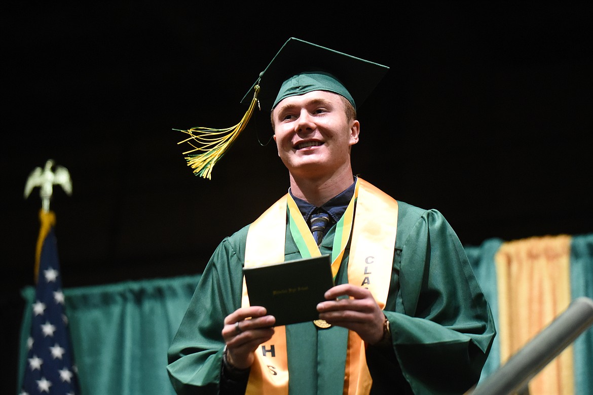 Logan Drown smiles with his diploma during Saturday's Whitefish High School Graduation. (Daniel McKay/Whitefish Pilot)