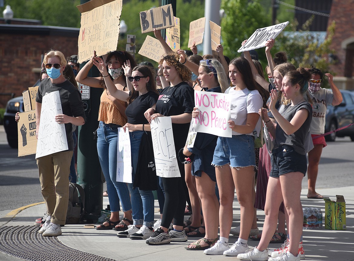 Protestors in front of Whitefish City Hall Wednesday wave to passing traffic. The group of demonstrators protesting the recent death of George Floyd and showing support for the Black Lives Matter movement grew to about 100 people at times. They received several honks of support from passing vehicles. (Heidi Desch/Whitefish Pilot)