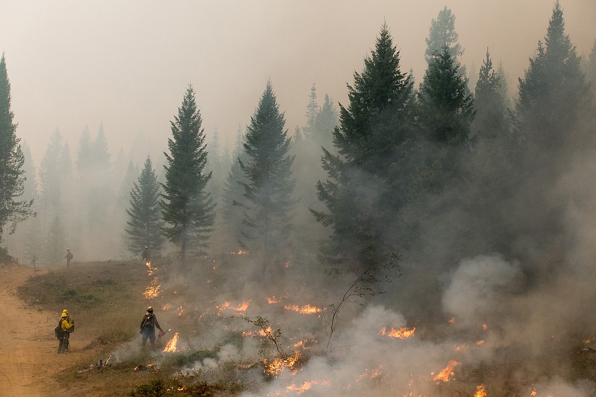 Mesa Hotshots and a Type 2 Hand Crew work a controlled burn on the West Fork fire north of Libby in 2017. County officials worry that a fire near the former vermiculite mine north of town could bring asbestos-laden smoke and ash into town. Commissioners last week agreed to pay for air quality monitoring in what is known as Operable Unit 3 in the future. (File photo)
