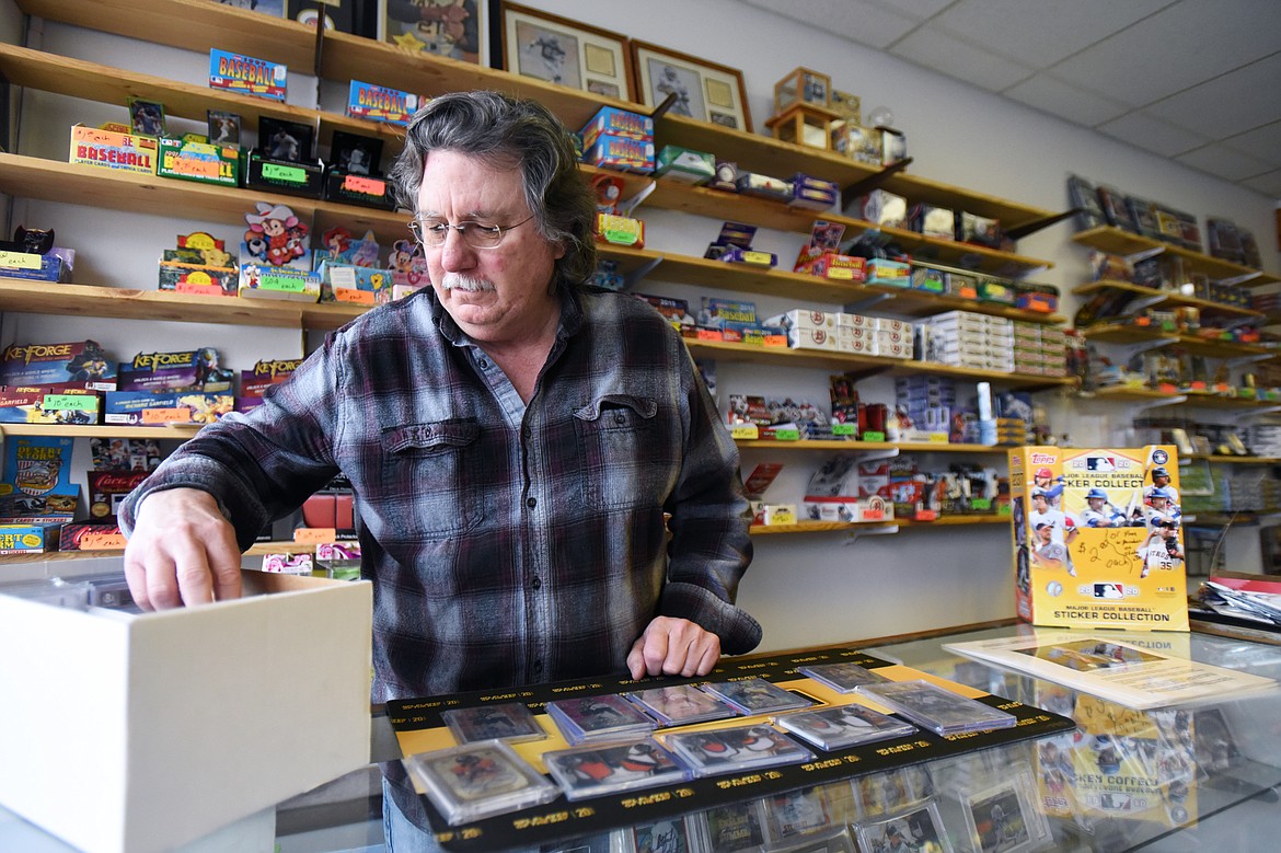 Tony Sibert, owner at Sports Cards Plus, sorts through cards at the front counter in Evergreen on Wednesday, June 10. (Casey Kreider/Daily Inter Lake)