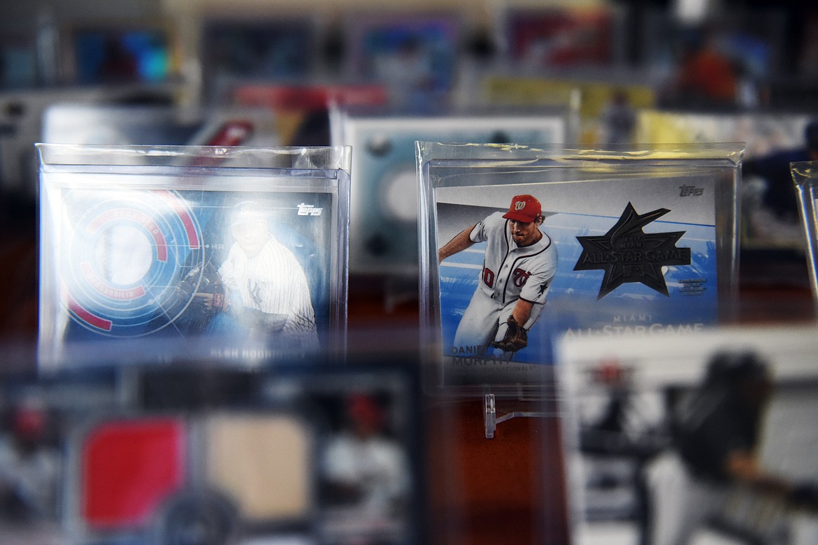 Sports cards reflect the light inside a display case at Sports Cards Plus in Evergreen on Wednesday, June 10. (Casey Kreider/Daily Inter Lake)