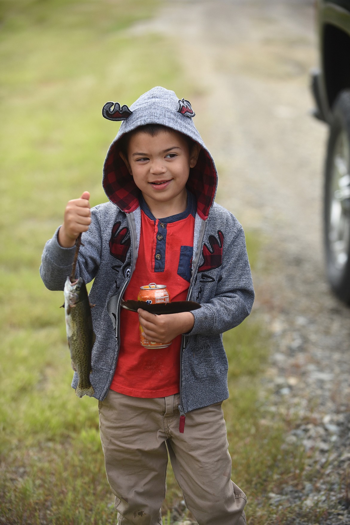 Hunter Reynolds, of St. Regis, shows off the rainbow trout he caught while fishing with his dad, Brian, June 13 at Kids Fishing Day at Savenac Pond in Haugan. (Scott Shindledecker/Mineral Independent)