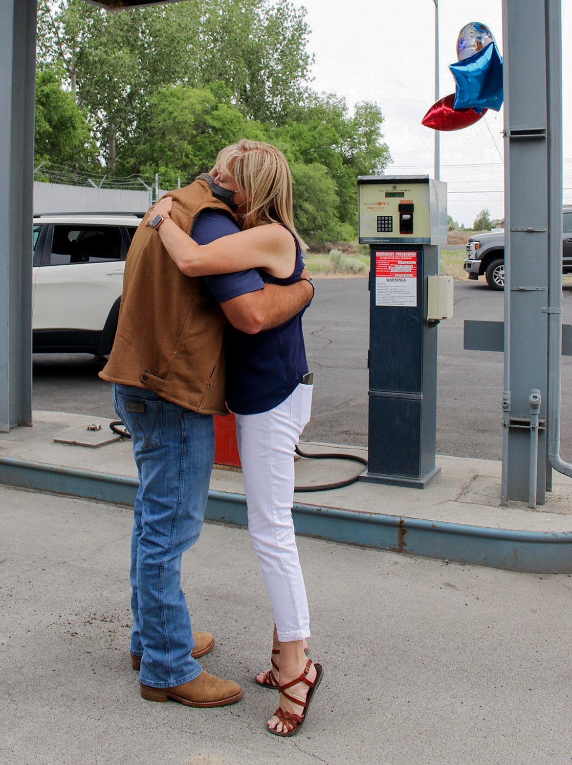 Kurt Adkinson embraces his wife, Theresa, after signing off with the Washington State Patrol for the final time last Friday afternoon.