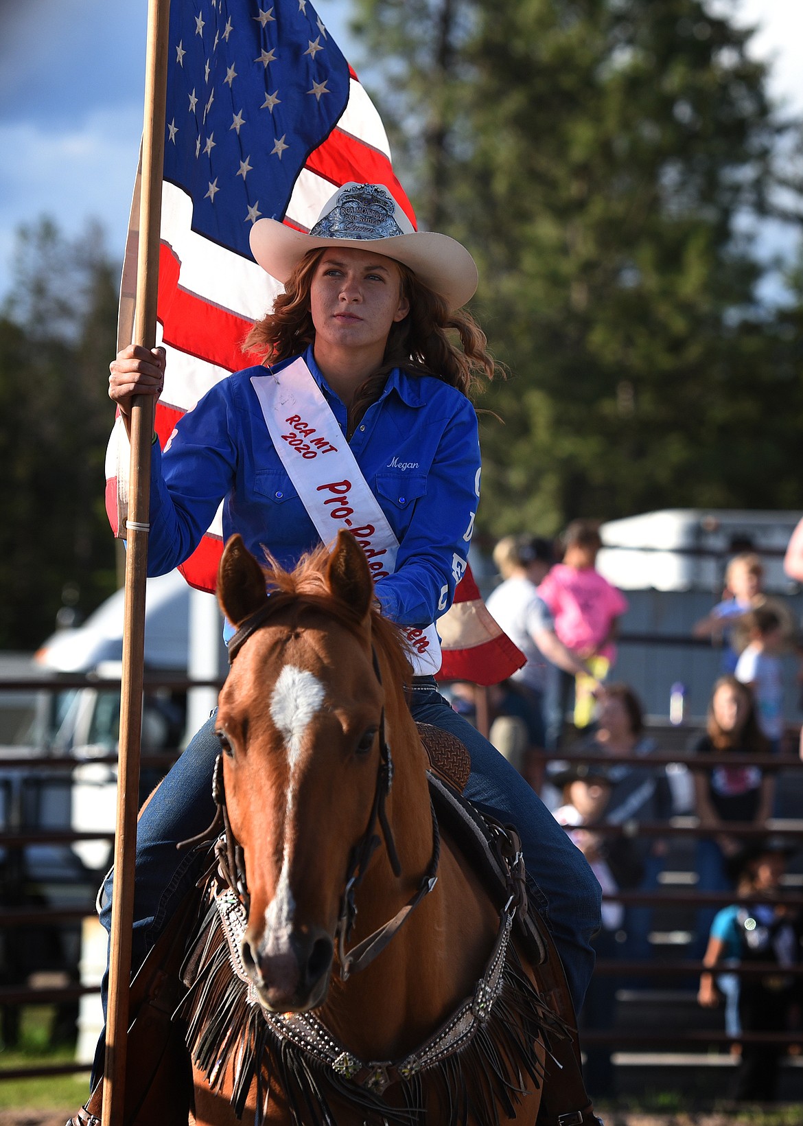 Megan Tutvedt, Rodeo Champions of America 2020 Queen for Montana, brings the American flag into the area on her horse, Peppy. (Jeremy Weber/Daily Inter Lake)