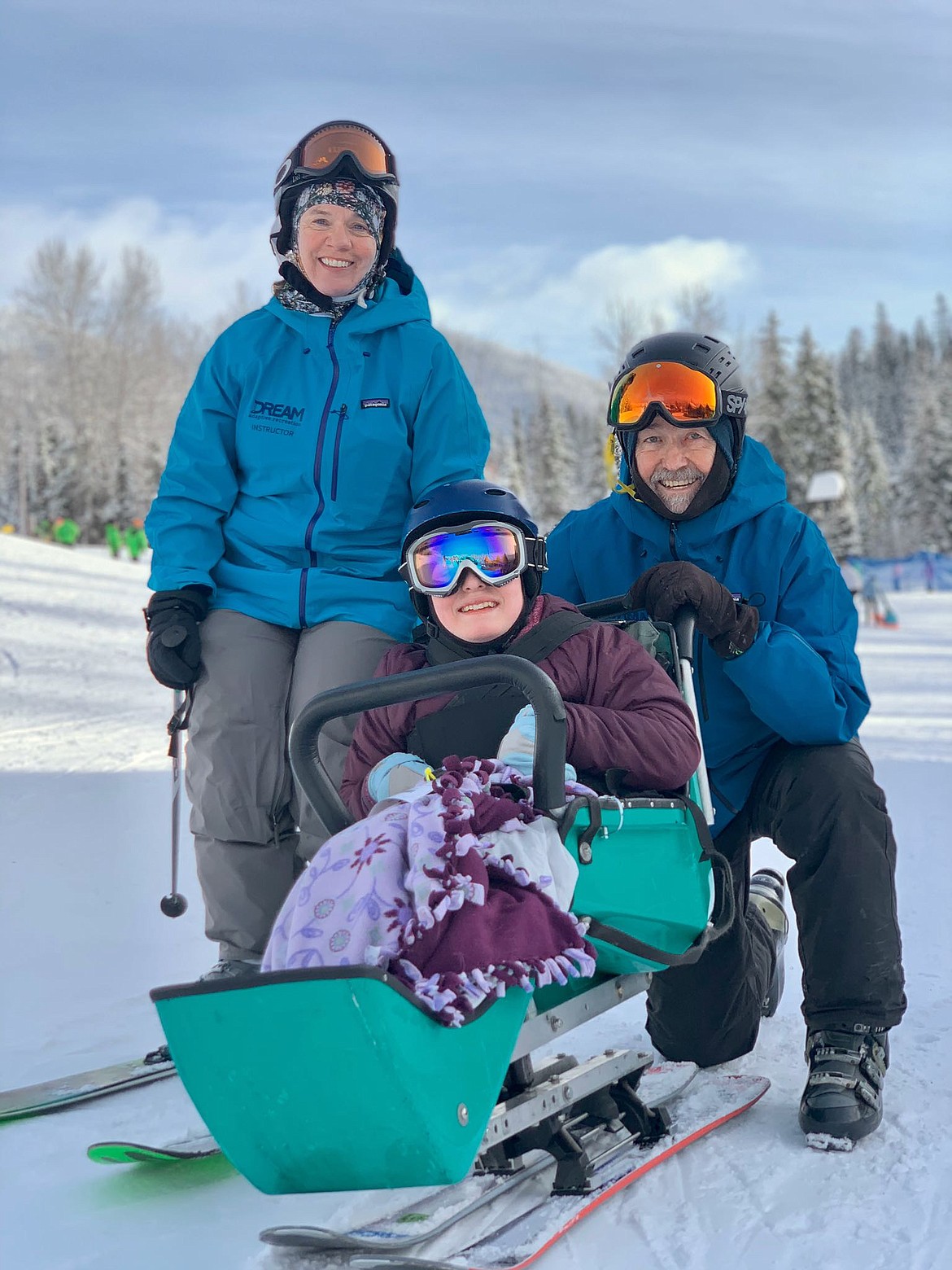 Volunteers Jenny Griswold and Jack Klovstad pose for a photo with a Glacier High School student at Whitefish Mountain Resort. Over 100 volunteers help run DREAM Adaptive’s programs, including the winter sit-ski lessons and group activities. (Photo provided by DREAM Adaptive Recreation)