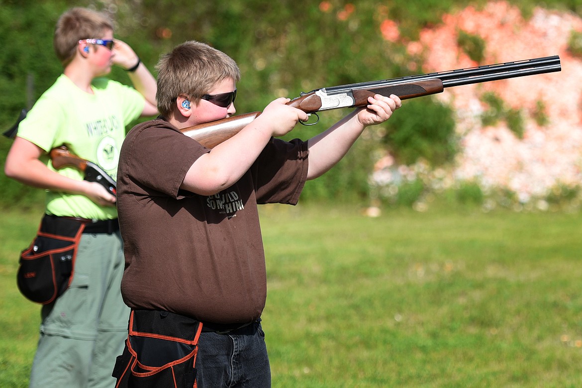 Ethan Kauffman (11) takes aim while his brother Nathan (15) looks on during clay target practice at the Bigfork Gun Club Thursday. (Jeremy Weber/Bigfork Eagle)