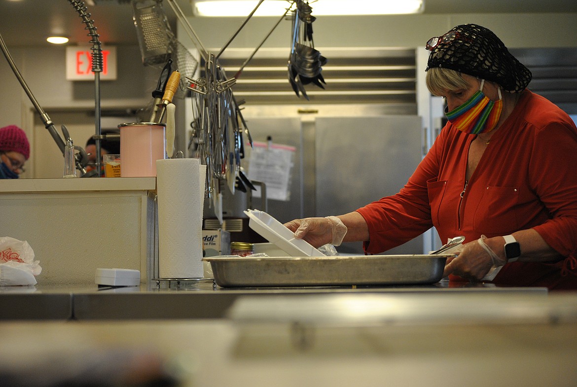 Hazel Cromwell prepares a to-go meal box during last Thursday’s dinner at the St. Regis Senior Center. (Amy Quinlivan/Mineral Independent)