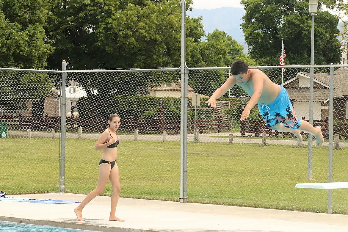 Twelve-year-old Arrow Hyde, of Plains, dives into the refurbished city pool last Saturday. Despite cool temperatures and rain, the weather cleared allowing kids to enjoy the pool for the first time since 2018. (Chuck Bandel/Clark Fork Valley Press)