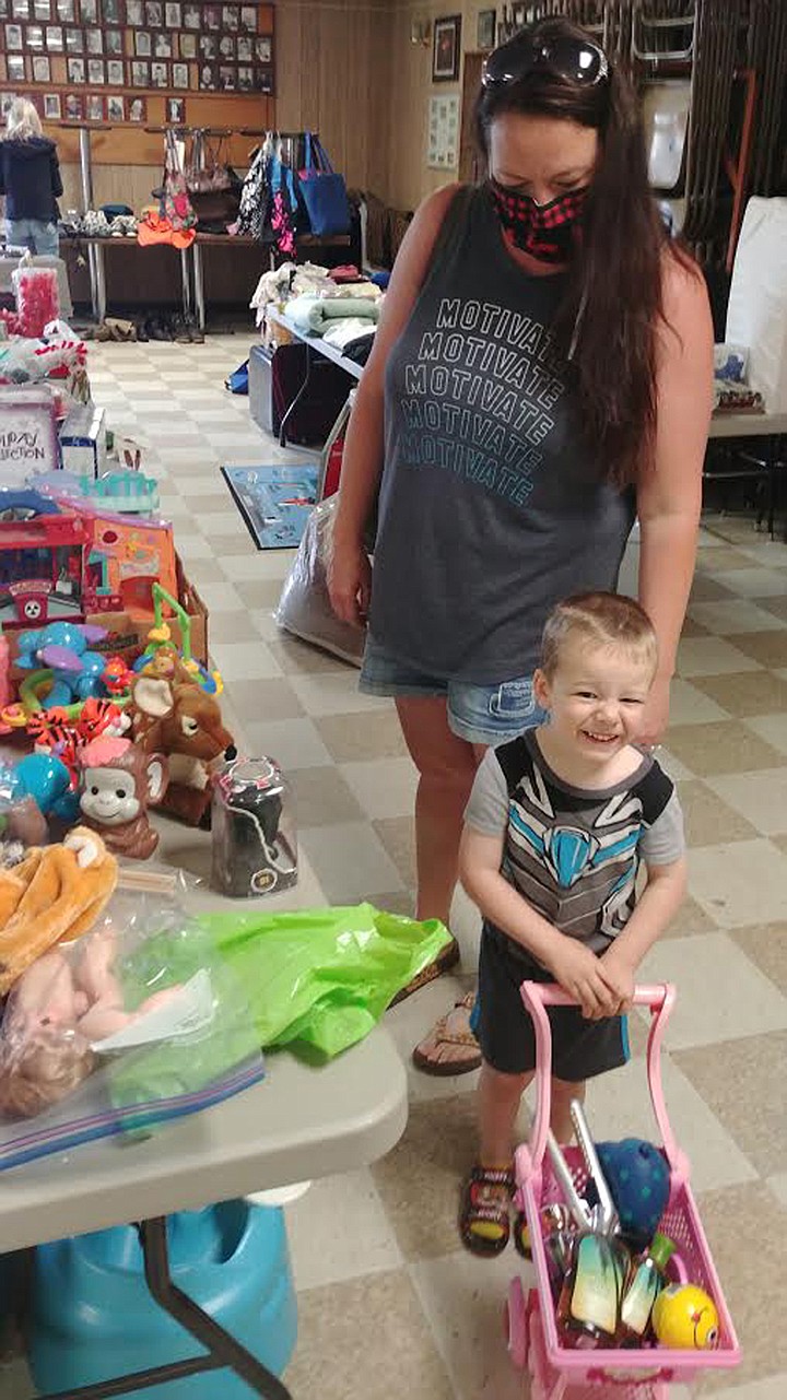 Plains residents three-year-old Kade Kinder and his mom Lisa, seek bargains at the Plains Woman’s Club rummage sale Saturday. (Chuck Bandel/Valley Press)