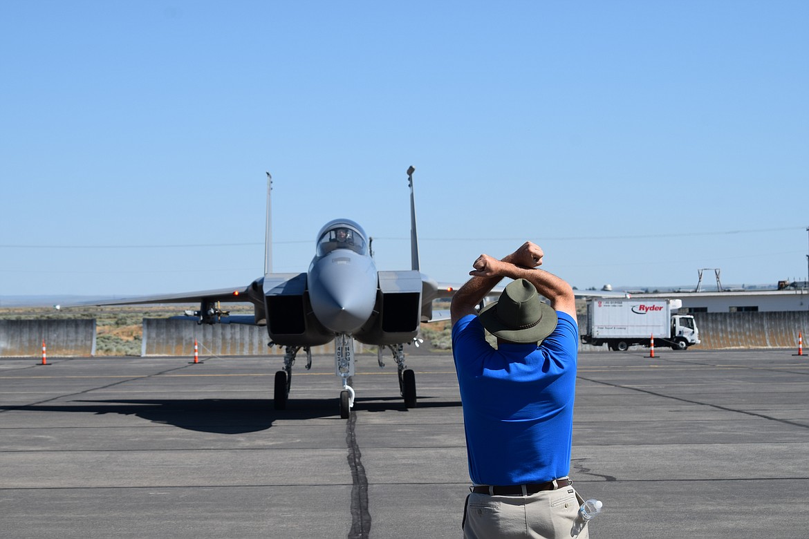Grant County International Airport Director Rich Mueller instructs an Oregon Air National Guard F-15 where to park at the 2019 Moses Lake Air Show.